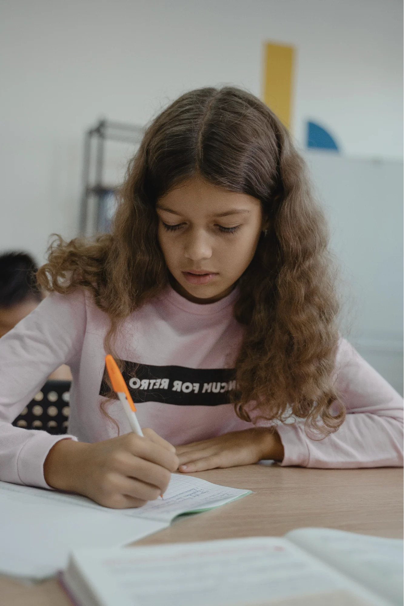 A learner writing at a desk