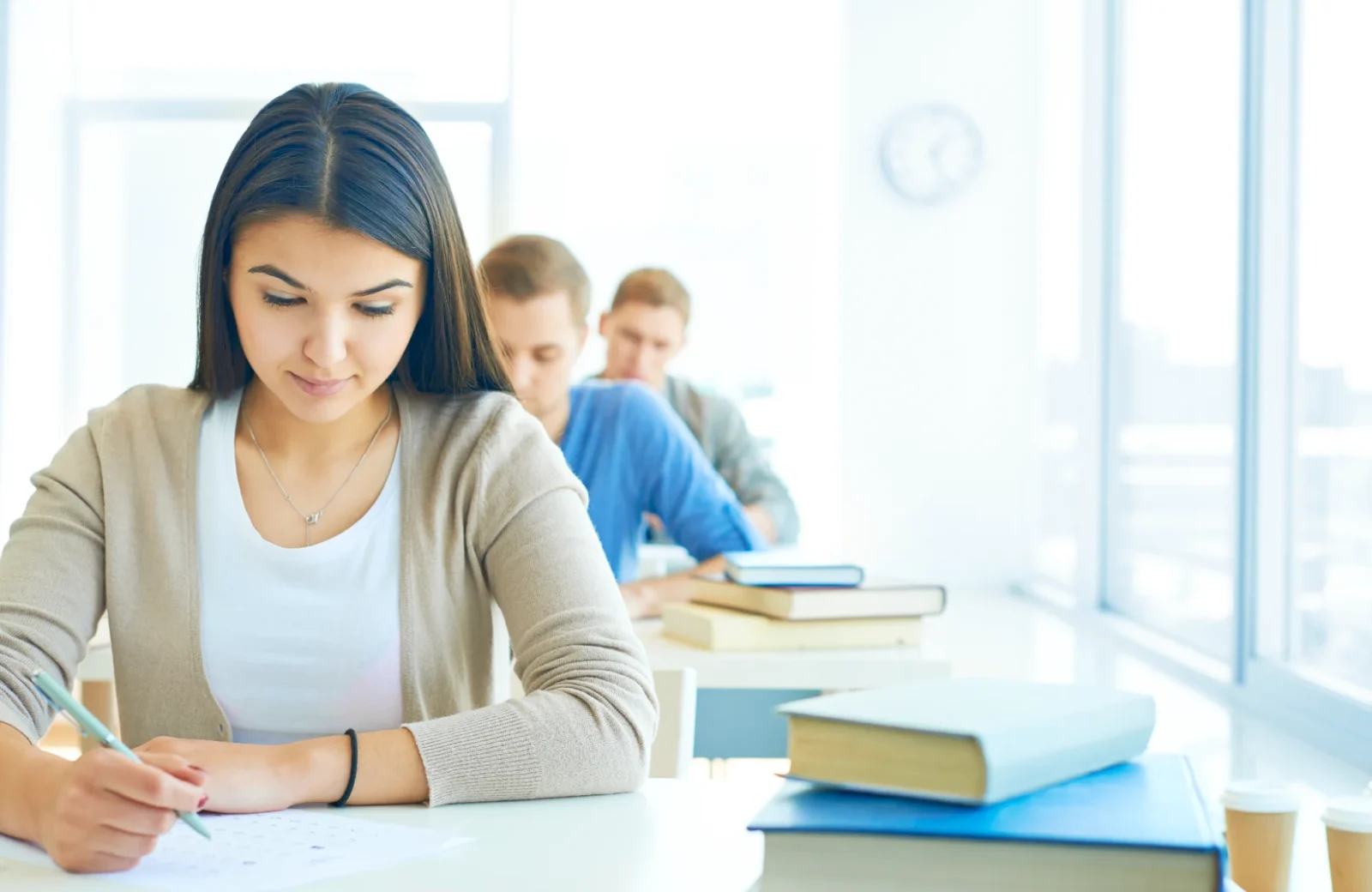Student writing in a notebook while studying